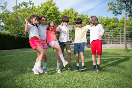 Free Happy children enjoying outdoor play on a green field in summer, showcasing friendship and joy. Stock Photo