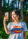 A Pretty Woman in White Shirt Taking Photos Using a Mobile Phone