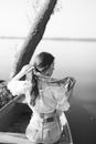 Grayscale Photo of Woman in White Dress Shirt and Skirt Standing Beside Tree