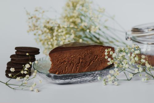 Free Indulge in a rich chocolate cake slice garnished with delicate flowers, perfect for dessert lovers. Stock Photo