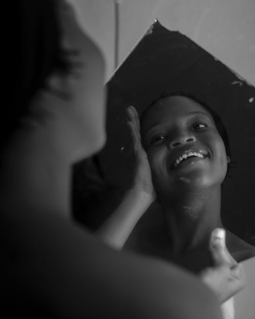 Free Grayscale Photo of a Woman Smiling in the Mirror Stock Photo