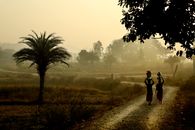 Man in Black Jacket Walking on Dirt Road