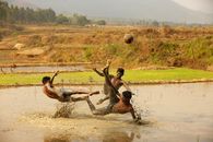Young men playing a lively football game in muddy fields at Araku Valley.