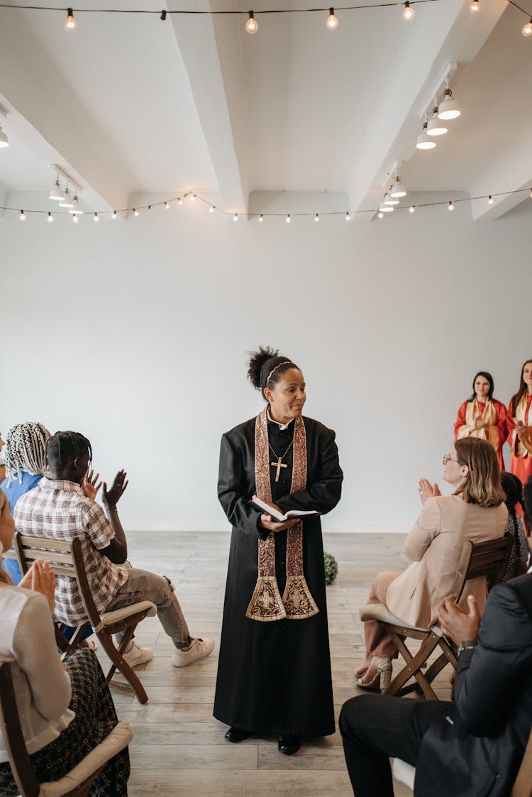 A Woman Pastor Holding Bible While Talking