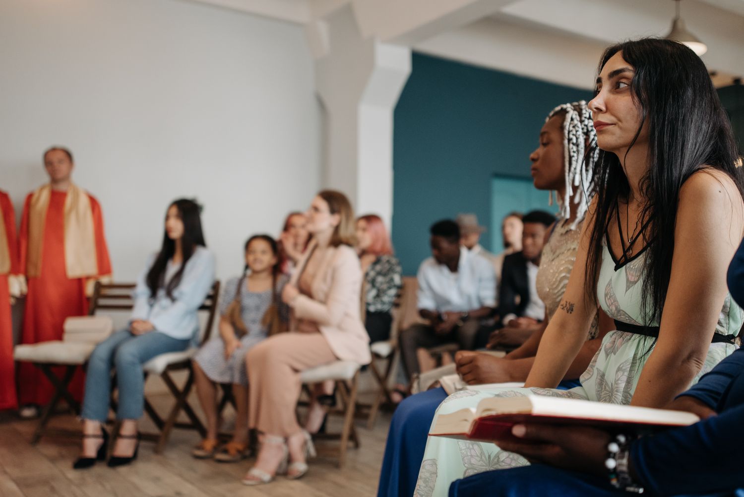 A multi-ethnic group of people attentively listening during a religious gathering