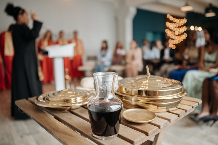 Golden Communion Trays An Bottle Of Wine On Wooden Table
