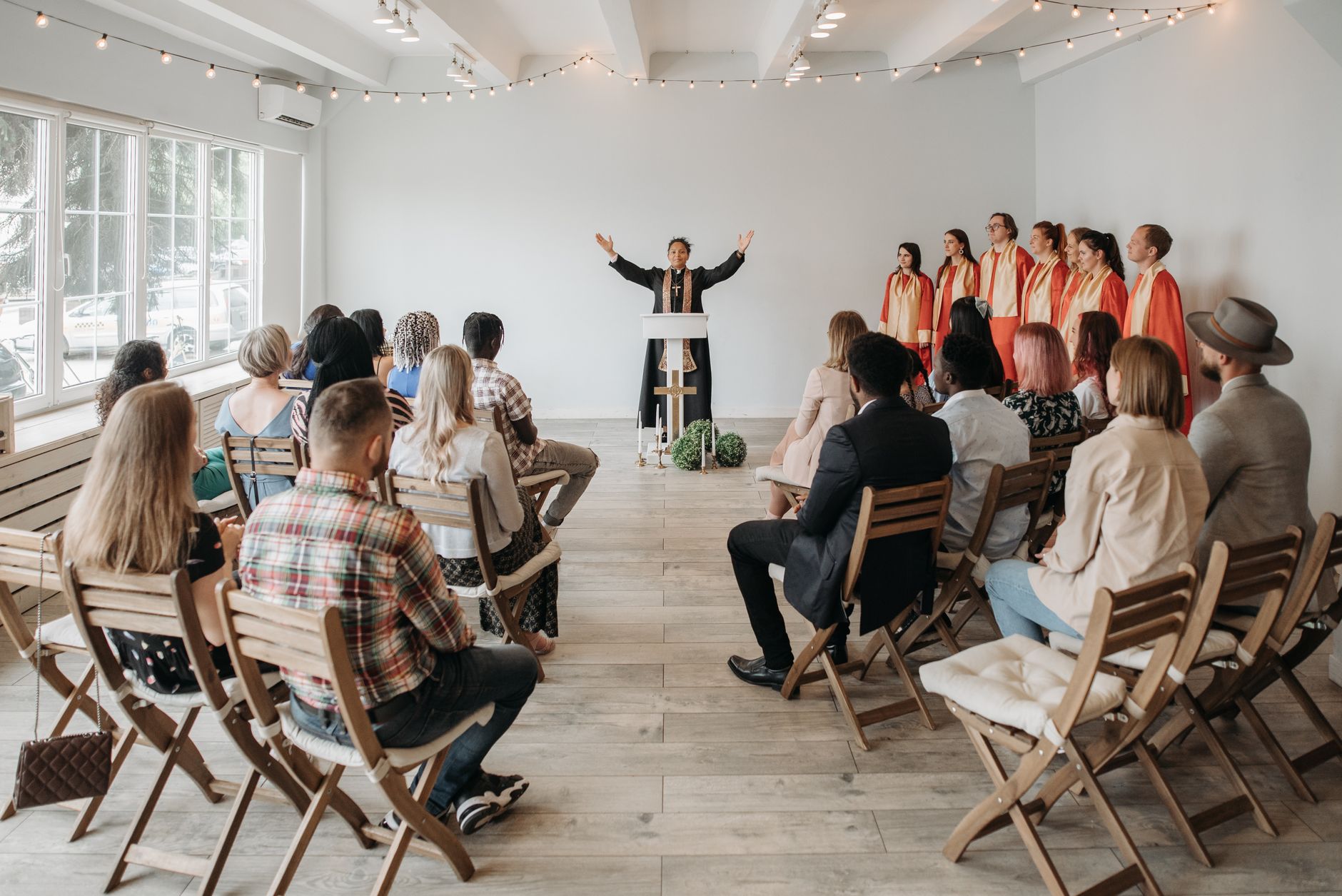A diverse congregation gathers for a lively church service with choir and pastor.