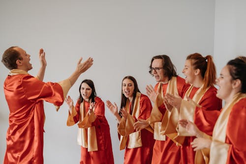 Church Choir in Orange and White Uniform Clapping 
 while Singing