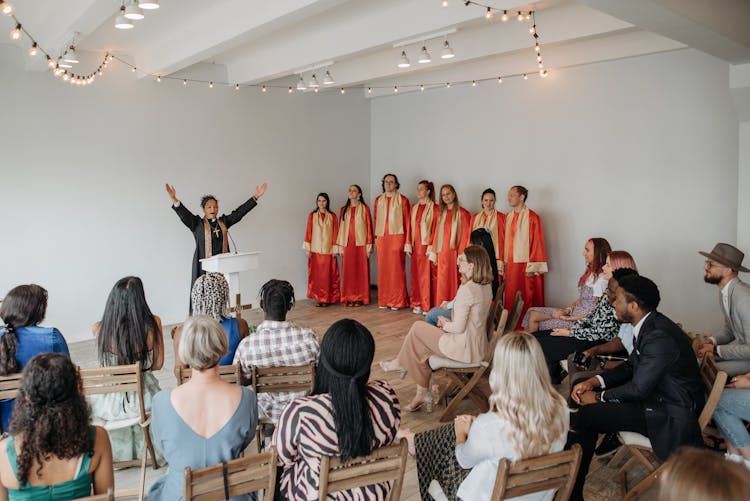 People Listening To A Female Pastor And A Church Choir