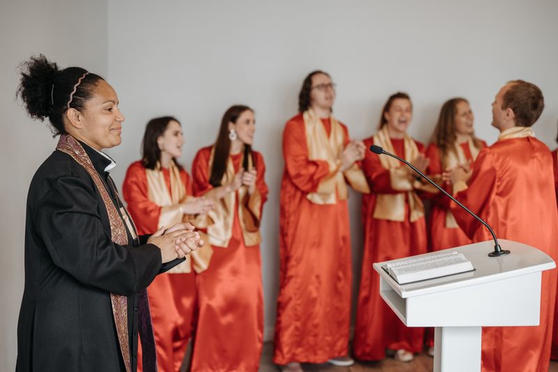 A diverse choir claps and sings passionately in a church setting