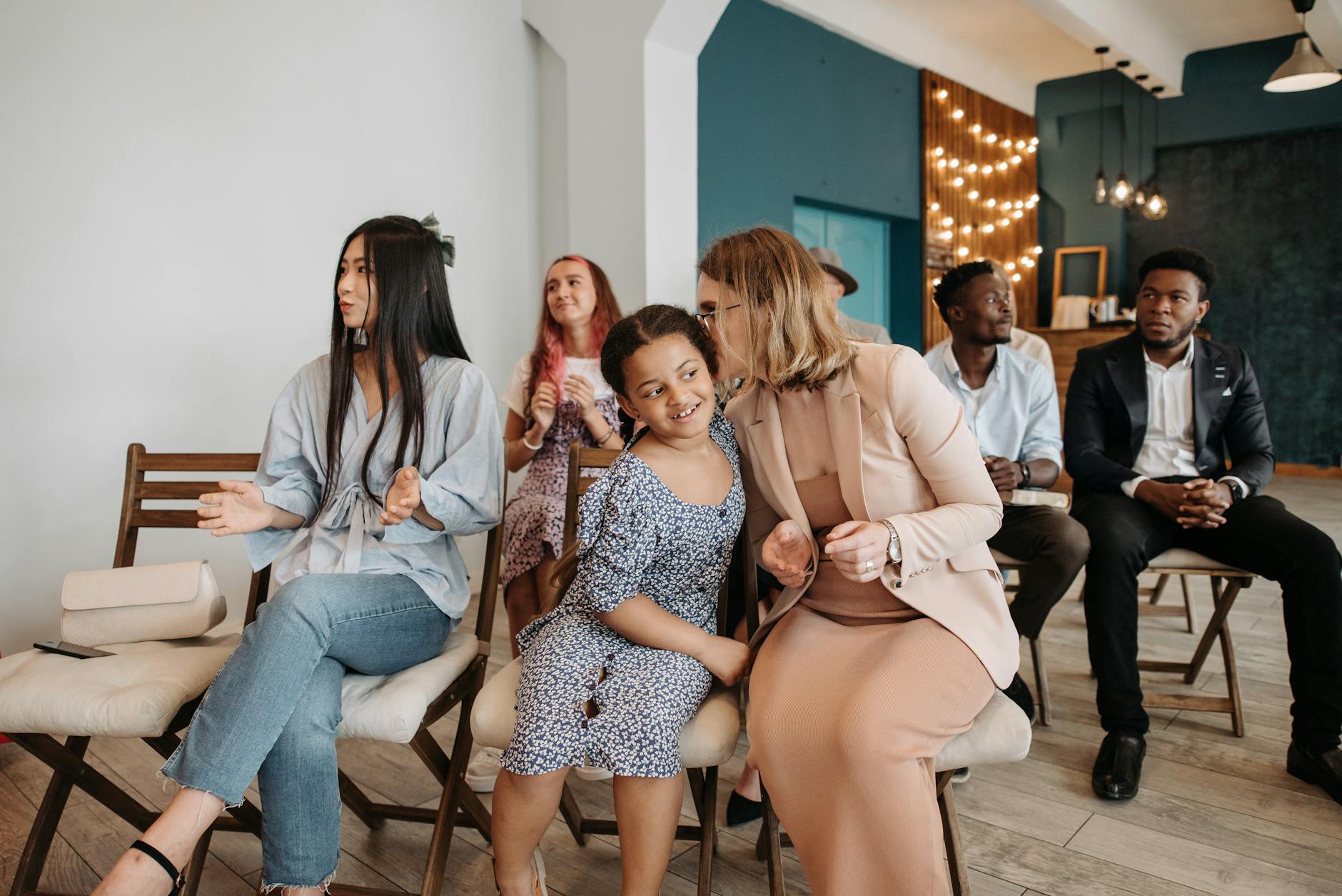 A diverse group of people applauding at an indoor event, showcasing community and engagement.
