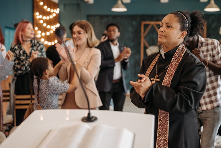 Priest And Congregation Clapping Hands In A Church