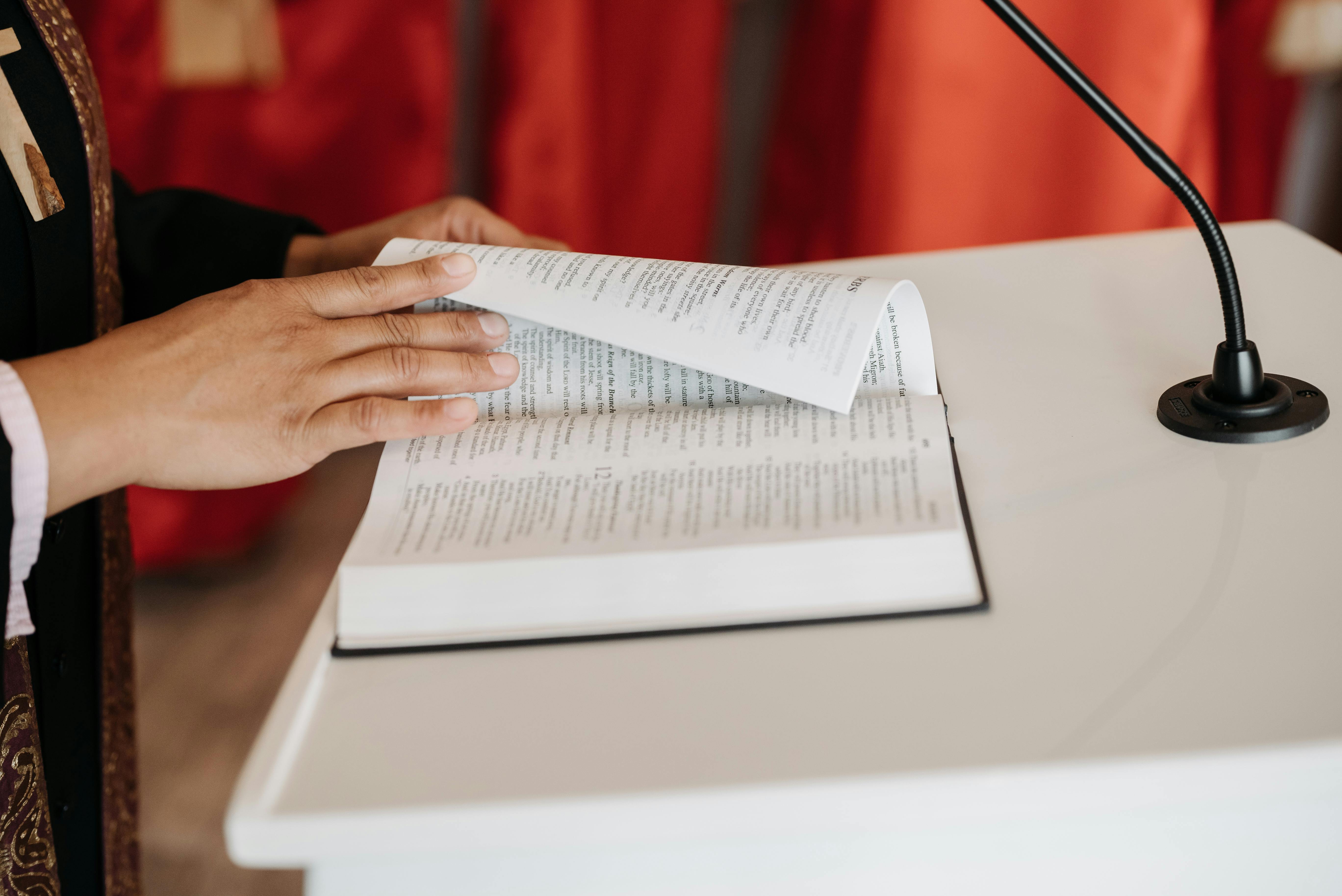 priest reading bible at the pulpit