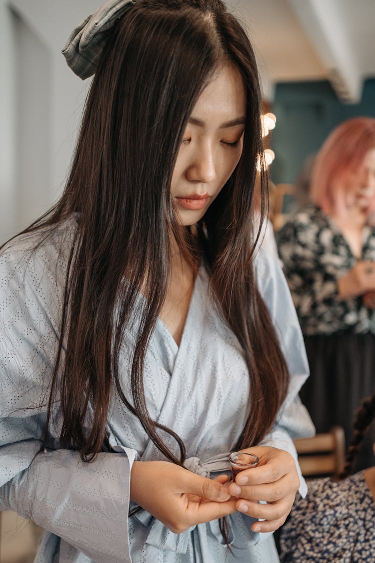 Woman In Long Sleeves Dress Holding A Tiny Cup