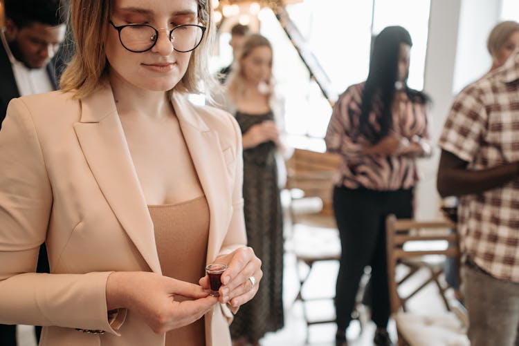 A Woman Holding A Communion Cup While Praying