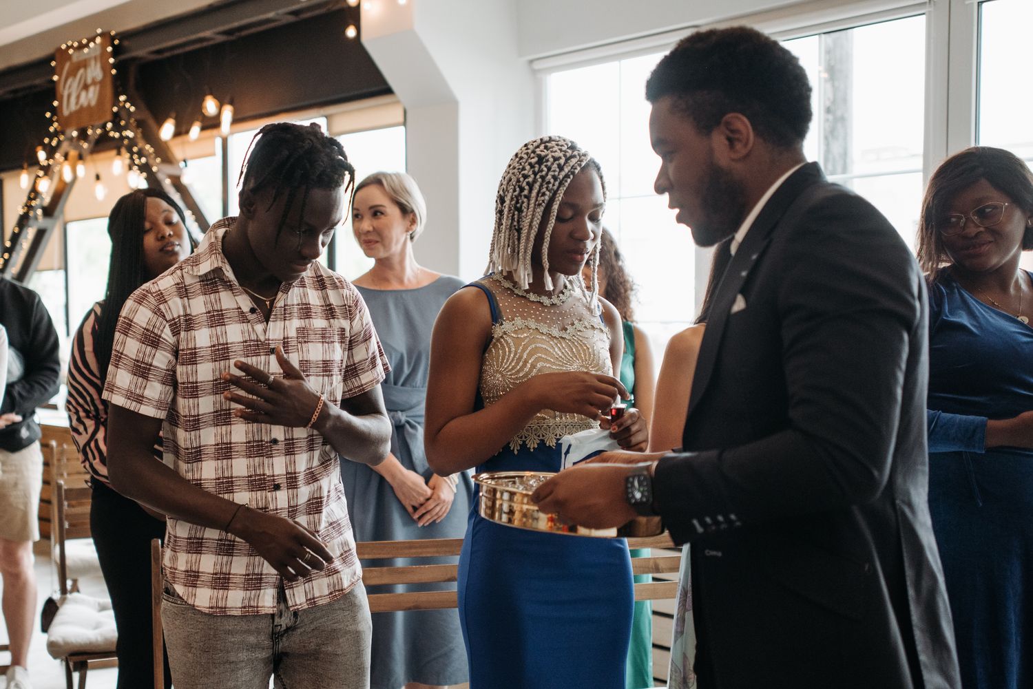 A diverse group of adults partakes in a communion ceremony inside a church
