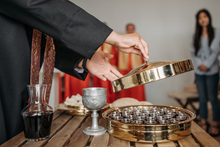 A Pastor Removing The Cover Of A Communion Tray