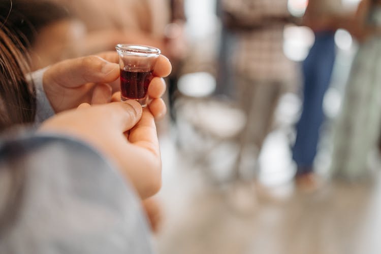 A Person Holding A Communion Cup