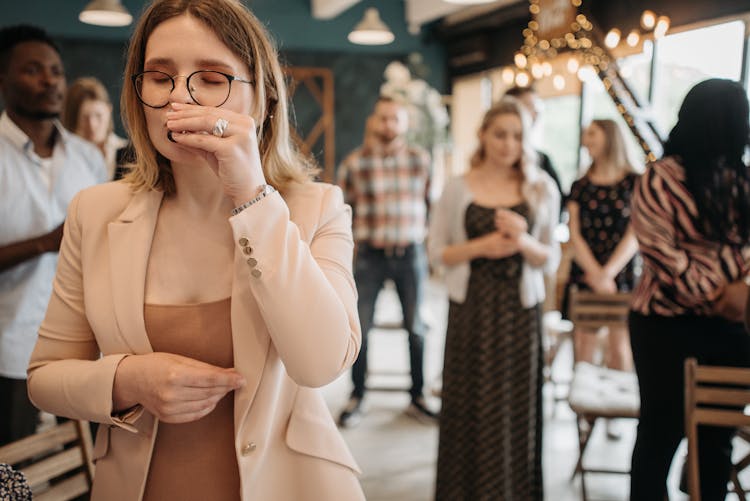 A Woman In A Blazer Drinking From A Communion Cup