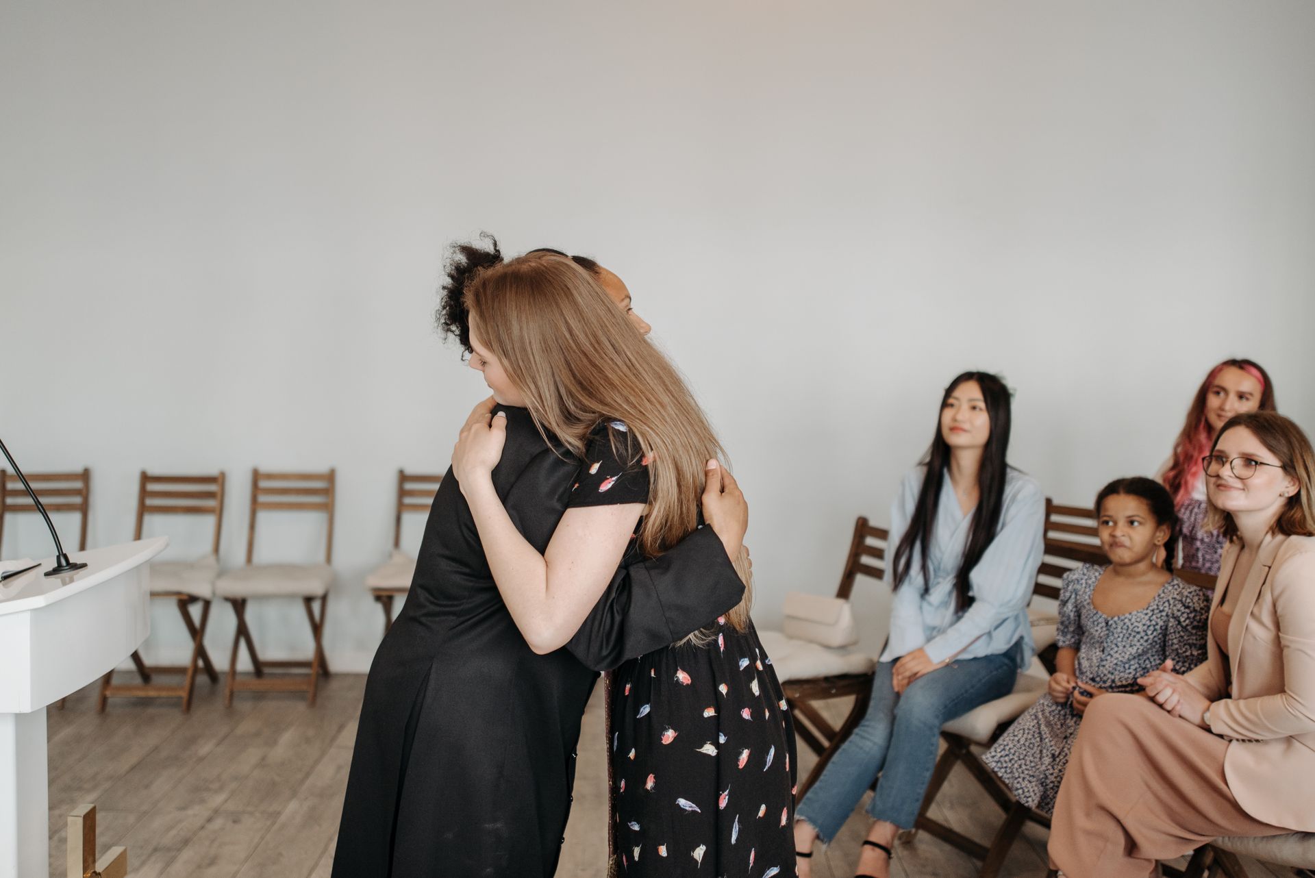 Women embracing and greeting one another after the gathering