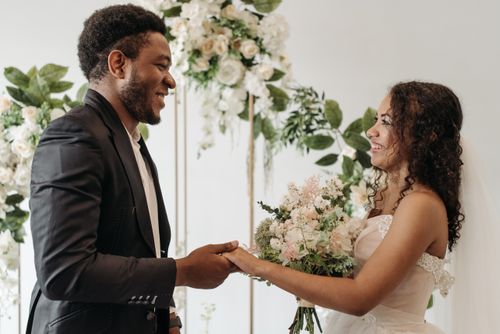 Free Beautiful wedding ceremony scene with happy couple holding hands and exchanging vows. Stock Photo