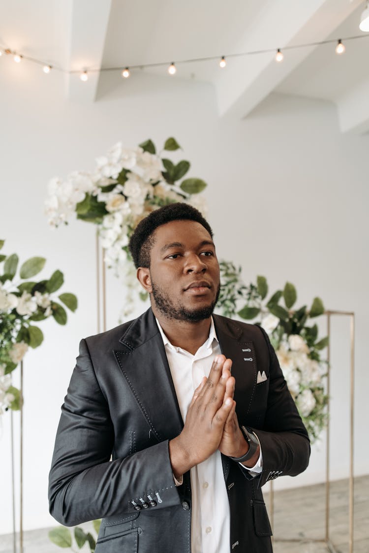 A Man In Black Suit Praying 