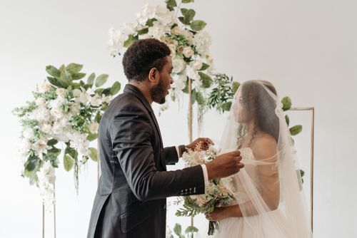 Free A beautiful bride and groom during an elegant indoor wedding ceremony. Stock Photo
