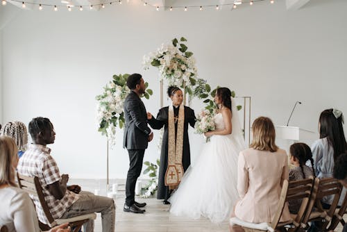 Free Female Pastor Marrying Bride and Groom in a Church Stock Photo