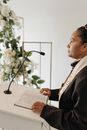 Woman Pastor standing behind a Lectern
