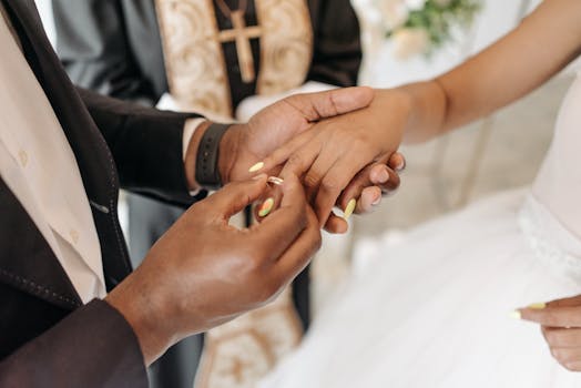 A groom places a wedding ring on the bride's finger during a touching and elegant wedding ceremony.