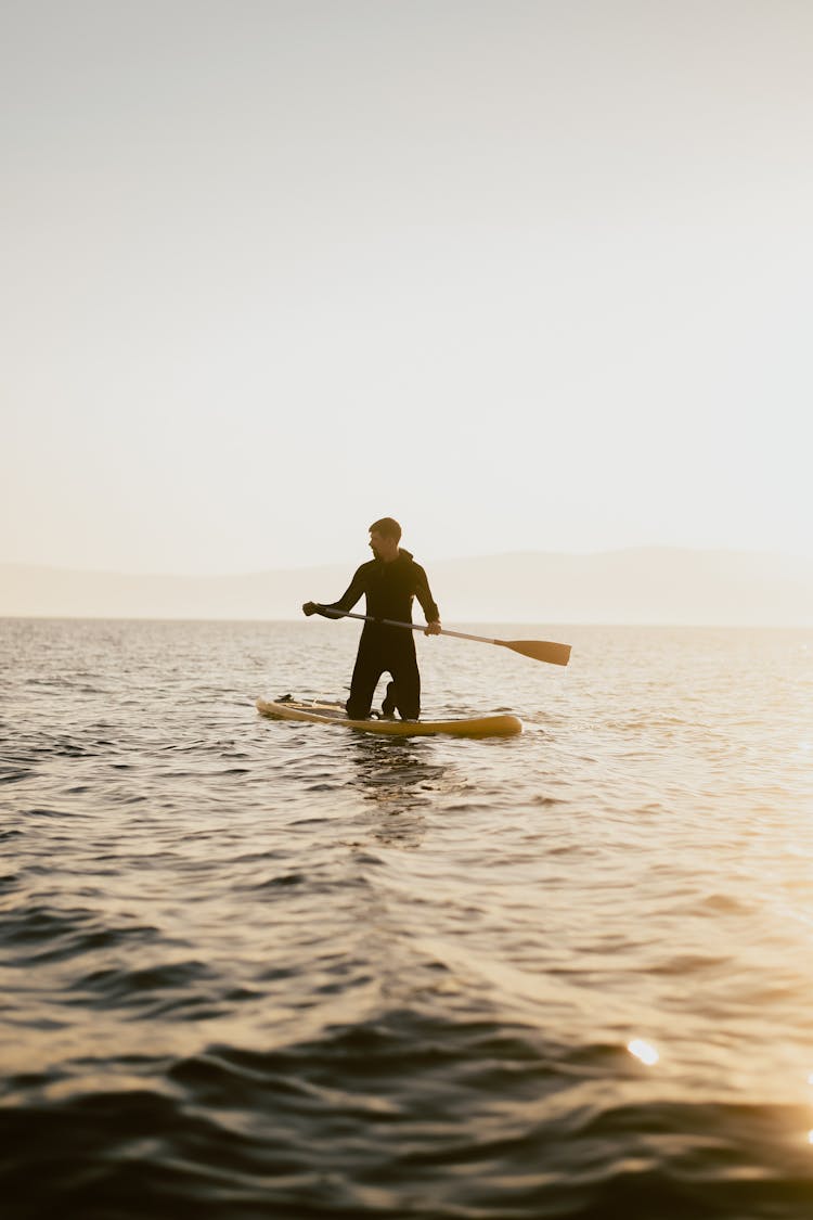 Man On Board In Sea On Sunset