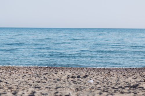 Free A tranquil beach scene with gentle ocean waves and clear skies, perfect for relaxing and enjoying nature. Stock Photo