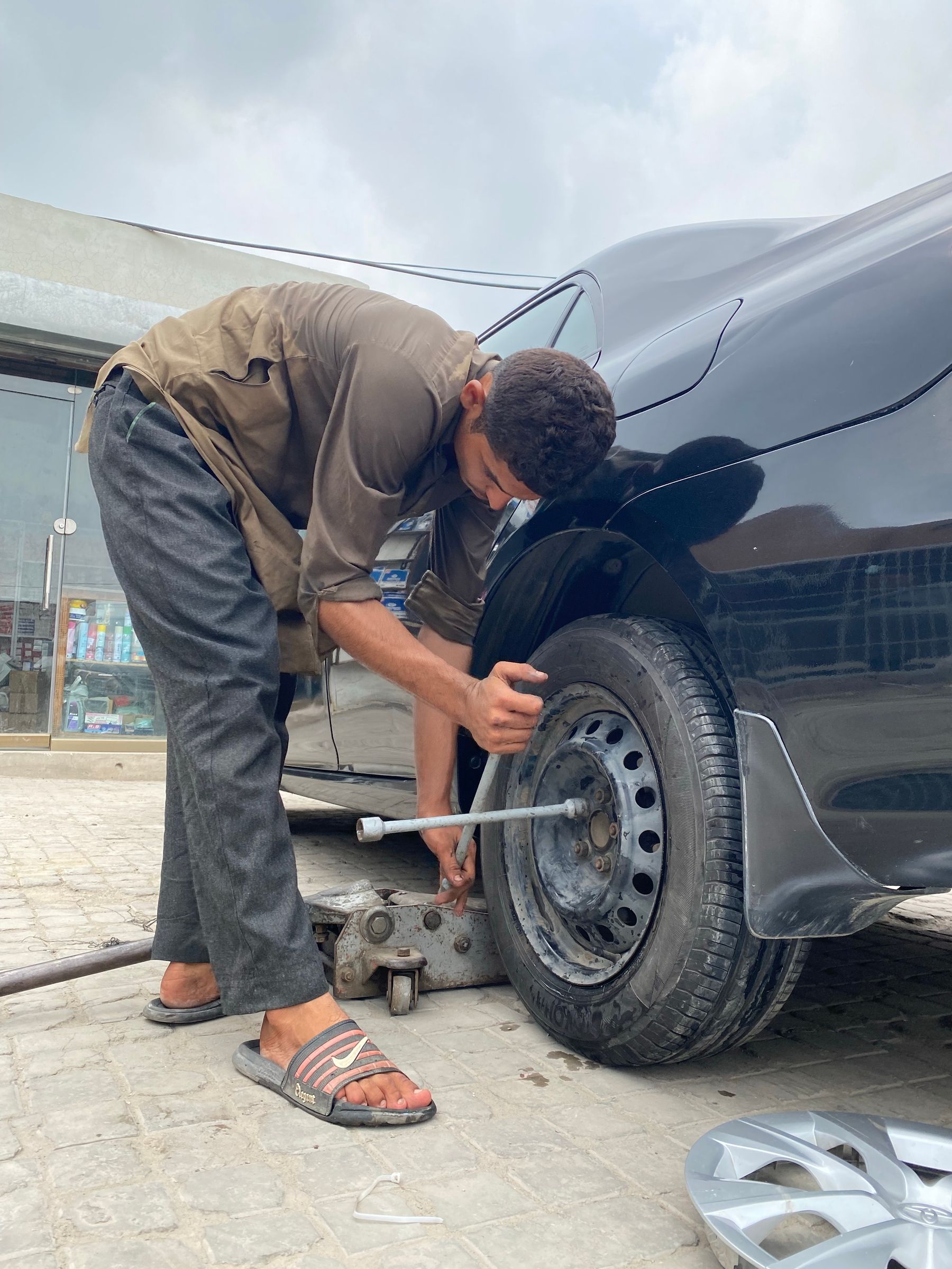 Tyre technician at work on a car wheel