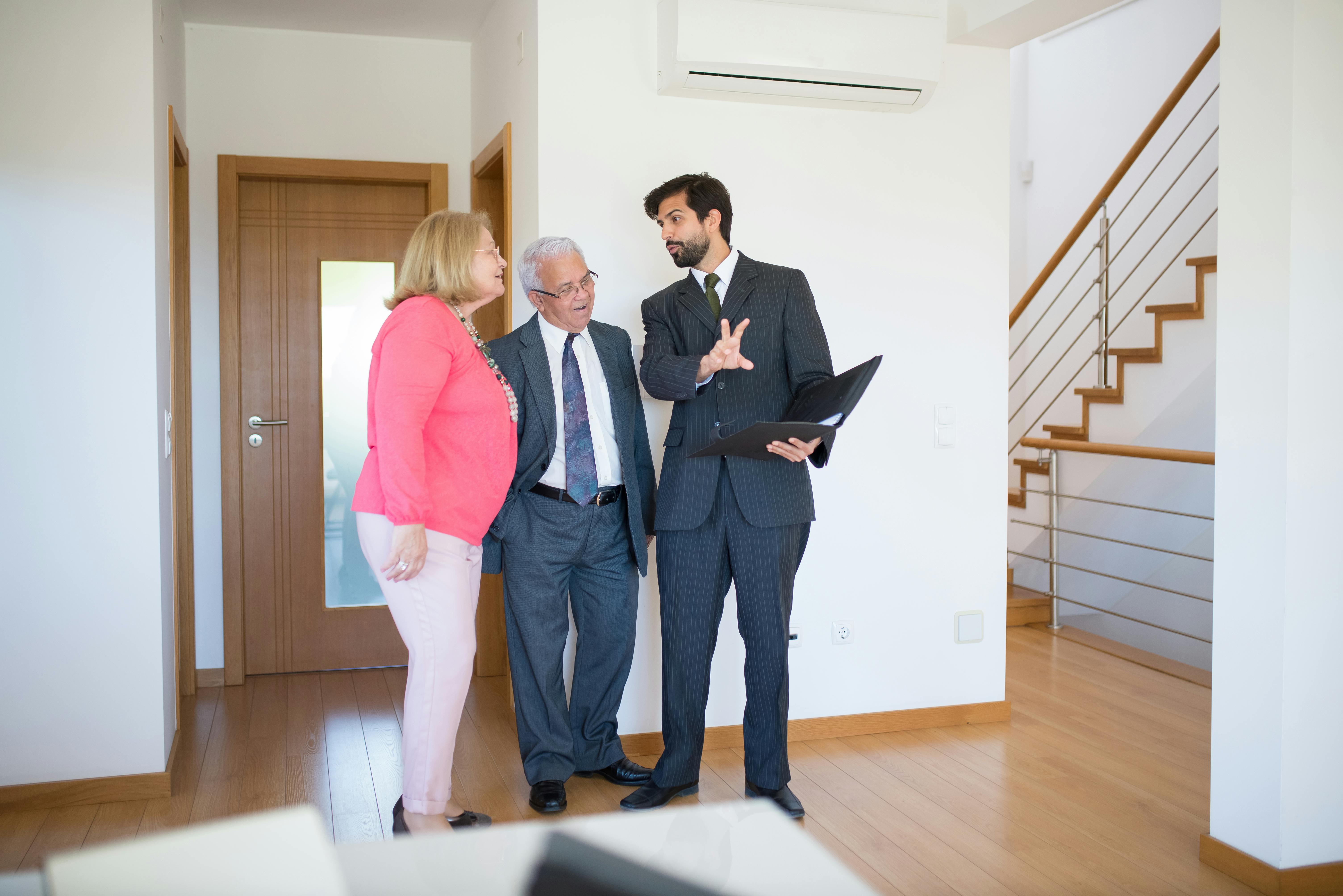 elderly couple talking to a real estate agent