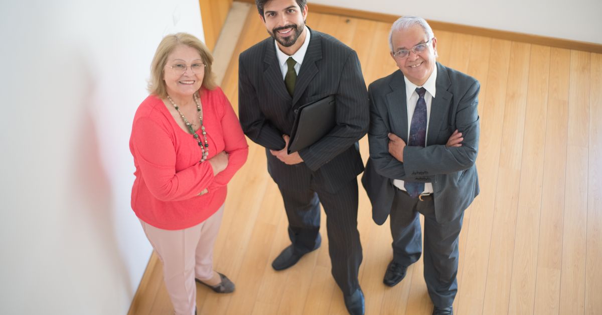 High angle view of a diverse team including a realtor with clients in a modern office.