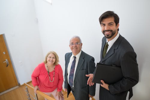 Elderly Couple and a Real Estate Agent  standing on Staircase