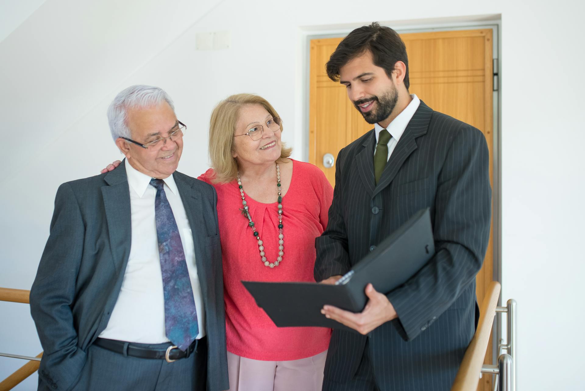 Elderly couple meeting with a realtor indoors to discuss real estate plans.