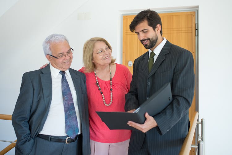 Real Estate Agent  Talking To An Elderly Couple