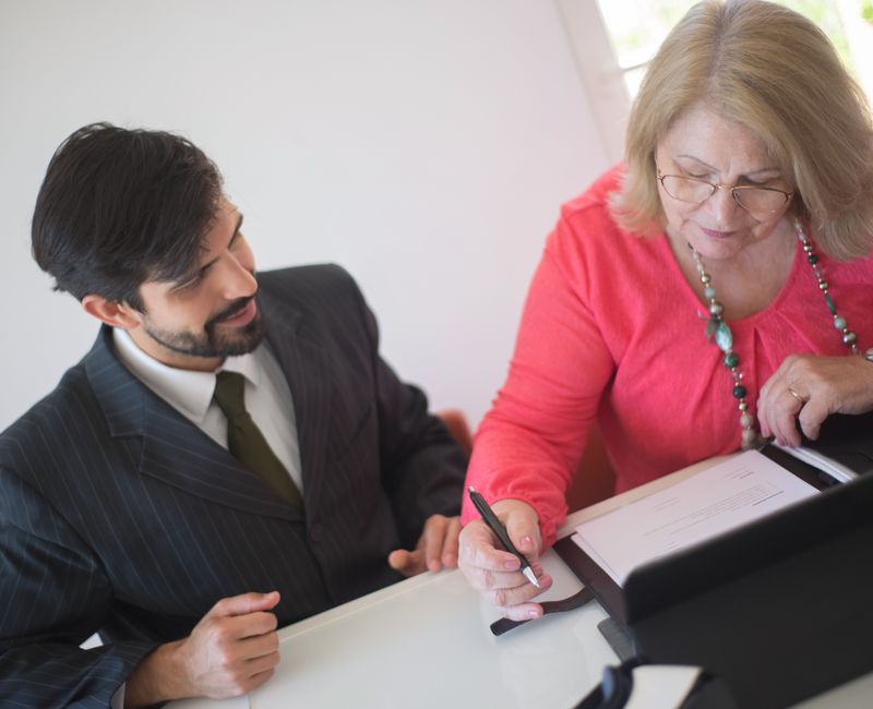 A notary public assisting a client with document signing at a desk