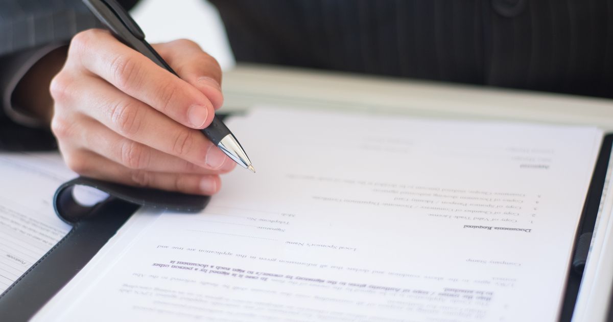 Main signant au stylo un contrat d’achat immobilier