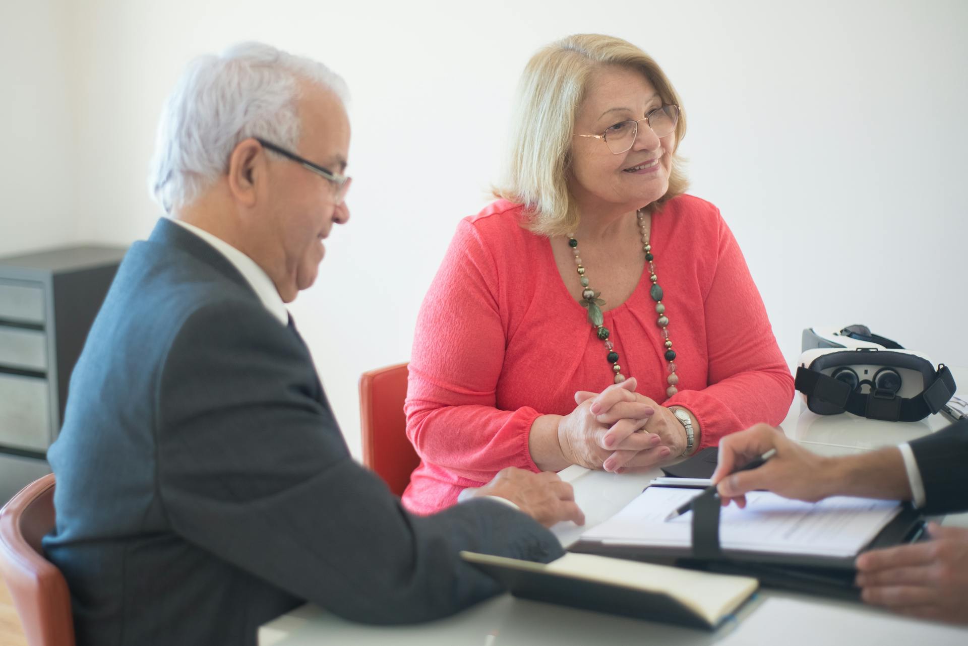 Smiling Senior Couple Listening to a Real Estate Agent Discussing About Home Mortgage