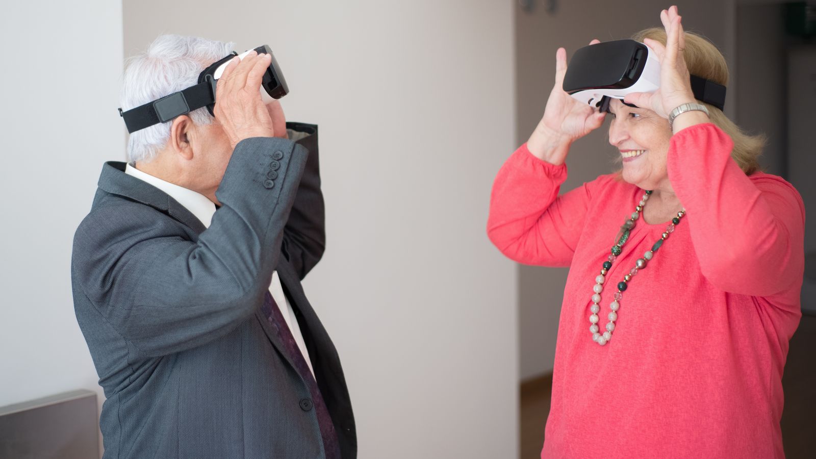 Senior couple exploring virtual reality with VR headsets, experiencing joy and technology.