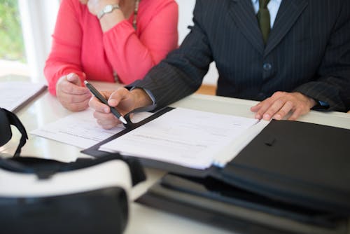 A Person's Hand Holding a Pen Near a Piece of Paper