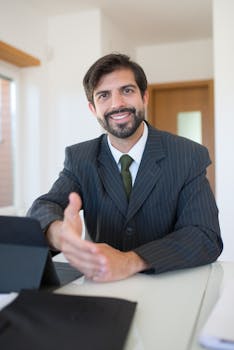 Real estate agent smiling in a modern office environment, ready for business transactions.