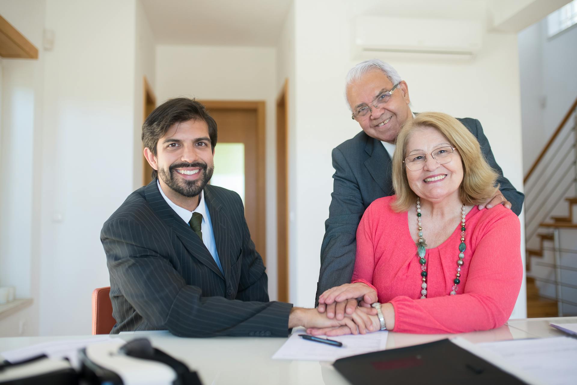 Smiling senior couple meeting with a professional advisor in a bright indoor setting.