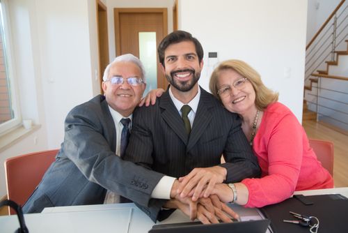 Free A joyful family embracing around a desk, symbolizing support and teamwork. Stock Photo