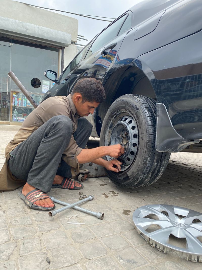 Tire tech tightening the lug nuts on a car wheel
