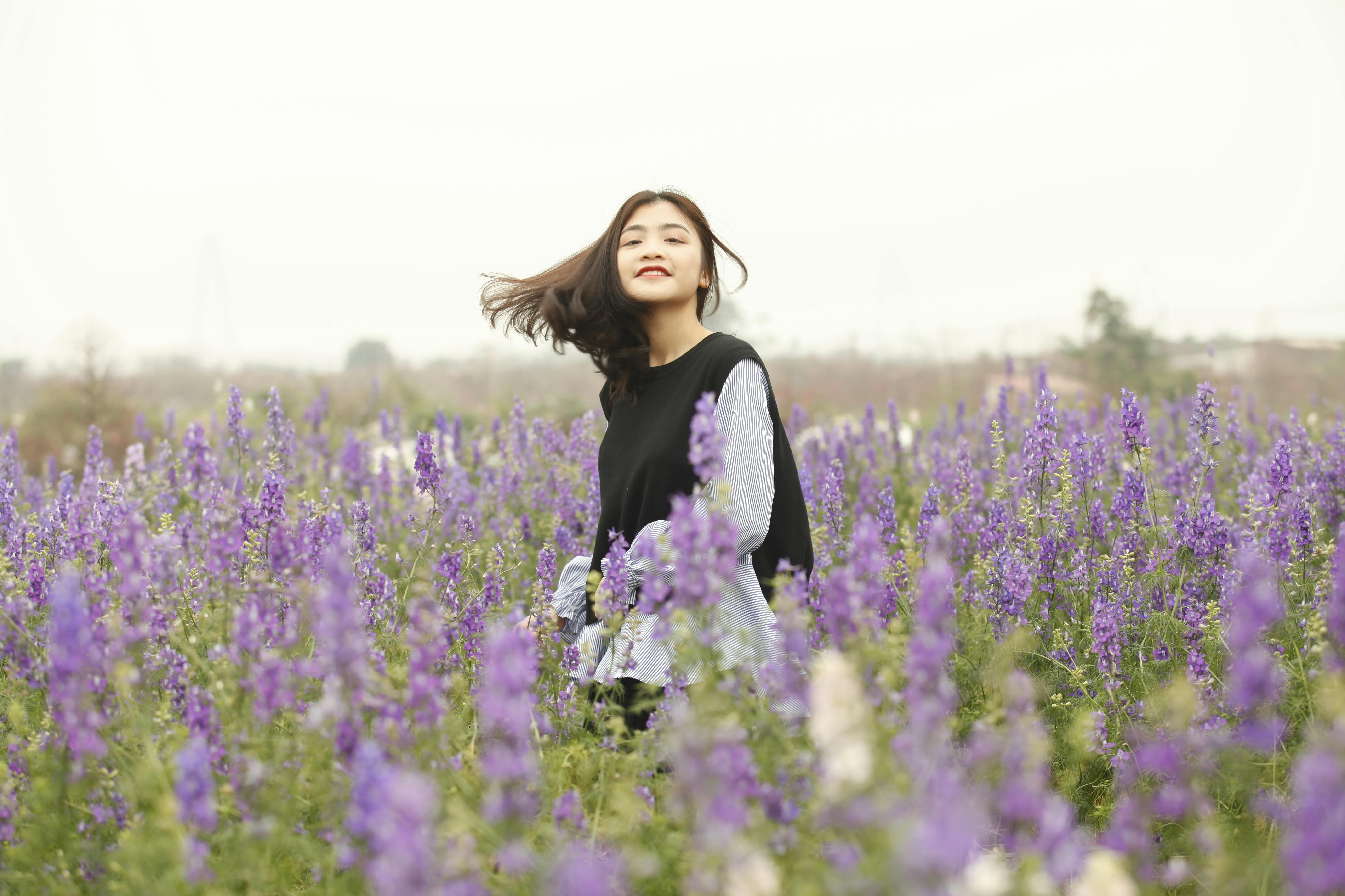 Young woman enjoying a vibrant lavender field outdoors.