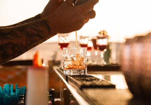 Free Barman with Tattooed Arms Making Cocktail  Stock Photo