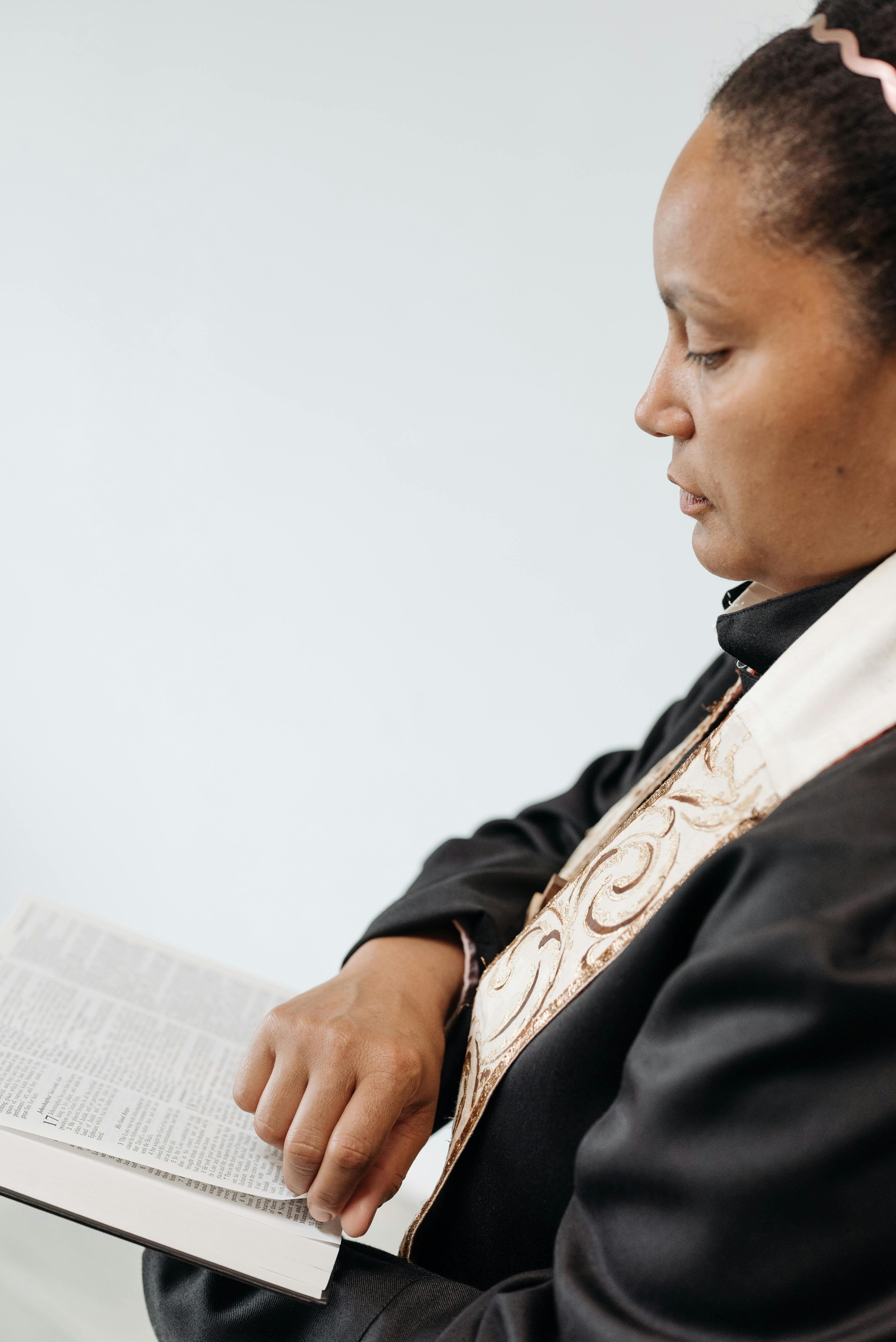 women in cassock holding bible